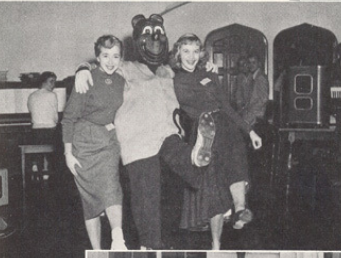 Archival scan: Oski dancing with two partners indoors. Photo credit: Photographer/artist uncredited in supplied scan.