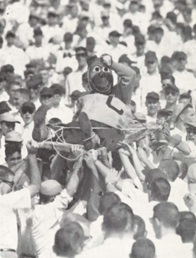 Archival scan: Oski being carried above a crowd. Photo credit: Photographer/artist uncredited in supplied scan.