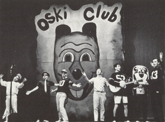 Archival scan: A stage performance beneath a large Oski Club backdrop. Photo credit: Photographer/artist uncredited in supplied scan.