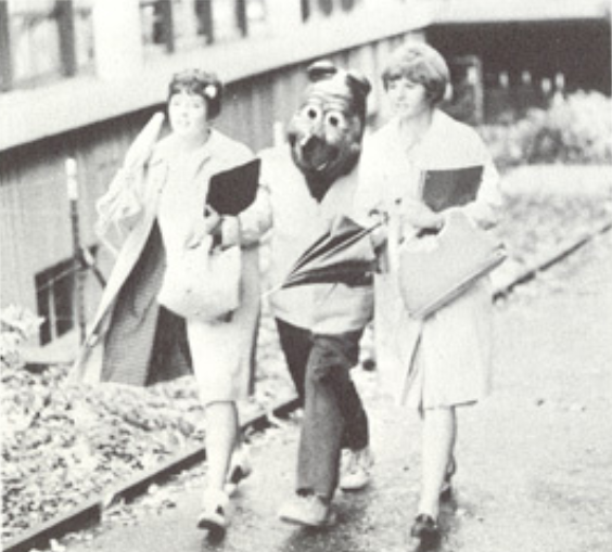 Archival scan: Oski walking with companions beside the stands. Photo credit: Photographer/artist uncredited in supplied scan.